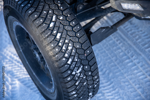 Quadro em tela Close-up of studded tire on snowy road for safe winter driving