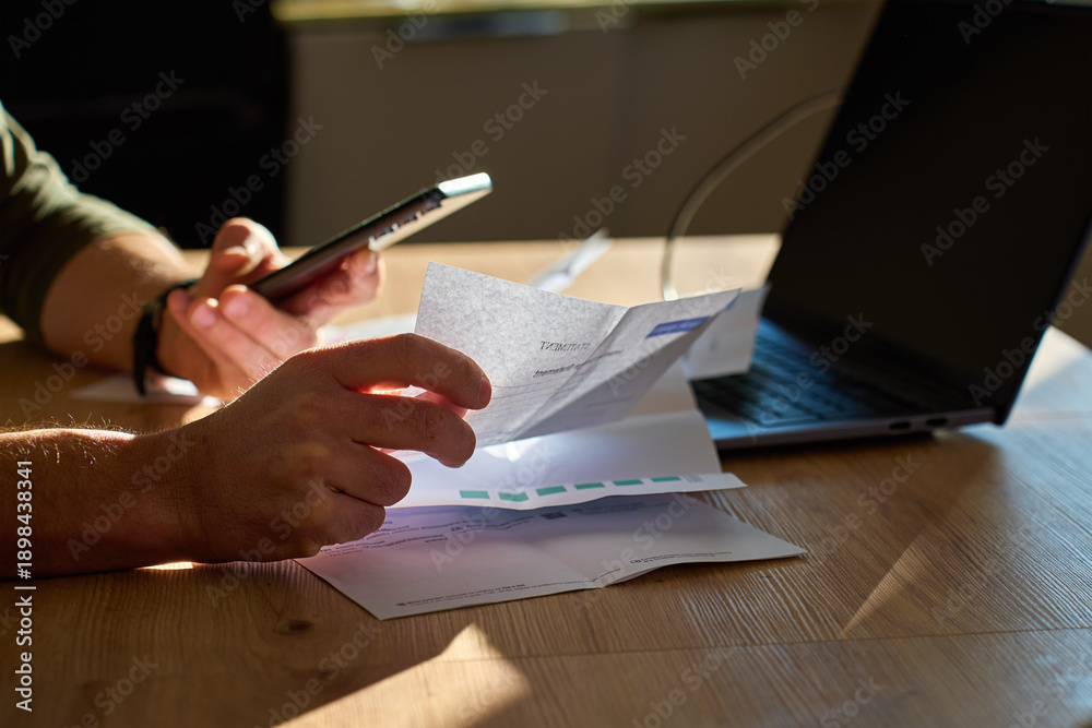 custom made wallpaper toronto digitalClose-up of man hands holding bills and smartphone near laptop on table at home. Concept of personal finance management, budgeting and financial stress.