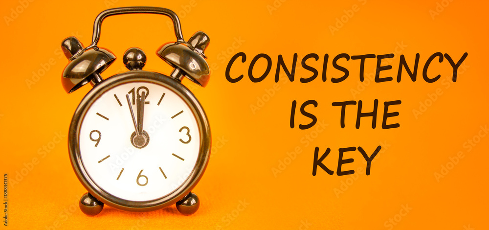Naklejka premium Consistency is the key symbol. Concept words Consistency is the key on beautiful orange paper. Beautiful orange paper background. Black alarm clock. Business consistency is the key concept. Copy space