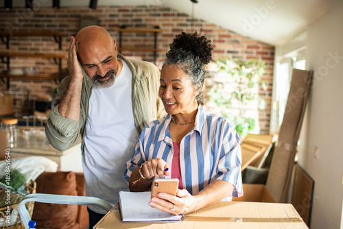 Photos Smiling mature couple planning a move in new home kitchen