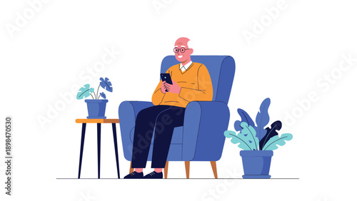 Elderly man wearing glasses sitting comfortably in a blue armchair while using his smartphone in a modern and cozy living room setting.