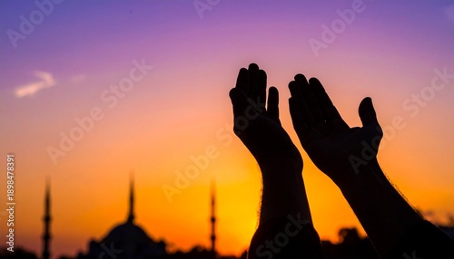 Silhouette de mains musulmanes en prière (Dua) avec une mosquée en arrière-plan au coucher du soleil, concept spirituel du Ramadan
