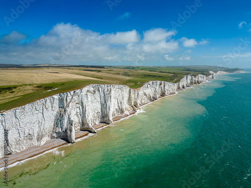 Aerial view of the chalk cliffs plunge dramatically into the turquoise sea, the iconic Seven Sisters standing sentinel against the horizon, Seaford, England, United Kingdom.