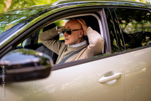 Φωτογραφία Stressful iddle aged man sitting in a car and driving in the city
