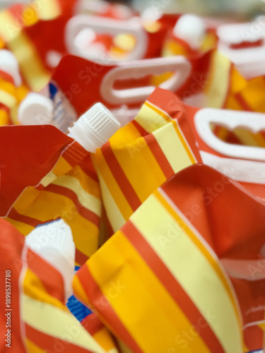 Plastic Pouch Display. Retail Presentation Featuring Vibrant Antifreeze Pouches With Twist Caps. Display Of Glossy Plastic Antifreeze Packs In Red And Yellow For Winter Vehicle Care