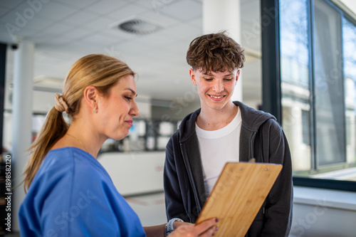 Tableau sur toile Doctor talking with teenage boy in medical clinic.