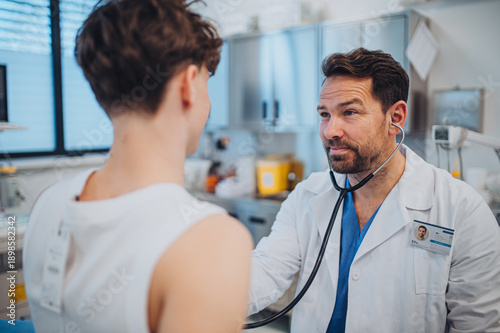 Cuadro en lienzo Cardiologist examining adolescent patient with stethoscope in clinic