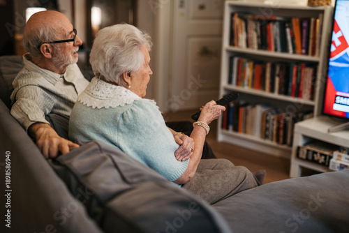Photography Lovely senior couple watching television in the evening.