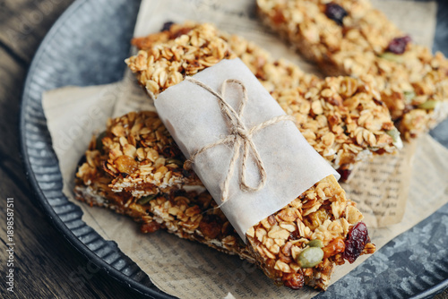 Gluten-free oat granola bars with nuts and berries on round vintage metal tray