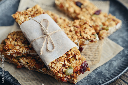 Gluten-free oat granola bars with nuts and berries on round vintage metal tray
