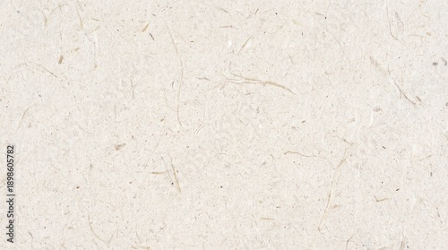 Close up of a light beige textured recycled paper background with visible fibers and speckles.