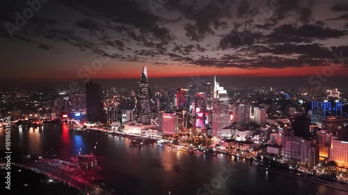 Ho Chi Minh City, Vietnam at night: 4K Aerial Night Drone Footage of Skyline, Skyscrapers, Bitexco Tower, Saigon River, illuminated Bason Bridge, Illuminated Streets, Busy Traffic in Evening