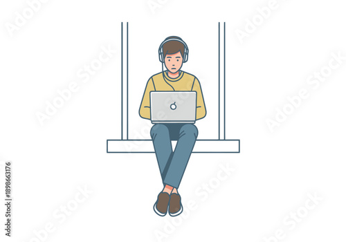 Young man with headphones using a laptop computer while sitting on a ledge focusing on digital work and online communication