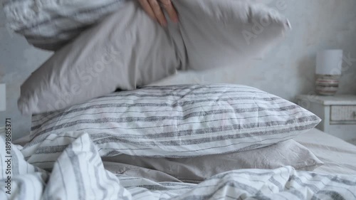 Wallpaper Mural woman makes bed, puts pillows and blanket on bed, smoothes sheet. cleaning house, change of bed linen. freshness and purity of home textiles. taking care of health of household. maid at the hotel. Torontodigital.ca