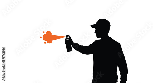 Silhouette of a person spray painting with orange paint