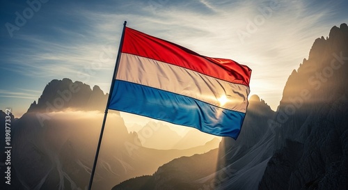 Luxembourg flag waving in mountain landscape at sunrise
