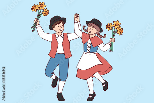 A joyful boy and girl wearing traditional Welsh clothes hold hands and dance merrily with yellow daffodils to mark the national spring celebration of Saint David's Day in the United Kingdom.