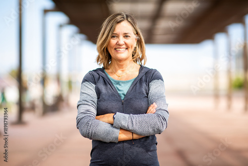 Confident mature woman with arms crossed in athletic wear