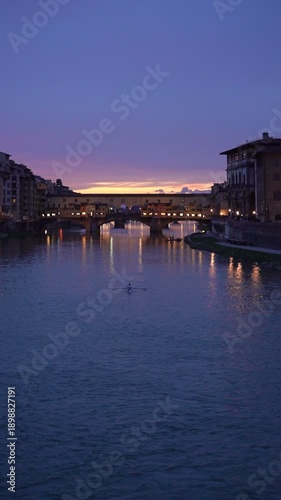 Vibrant night scene of the iconic Ponte Vecchio bridge during the blue hour in Florence, Italy
