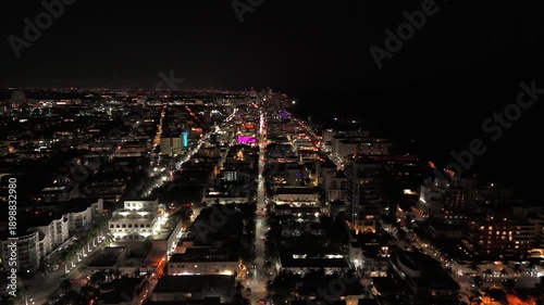 Aerial view of Miami Beach grid and glowing shore at night