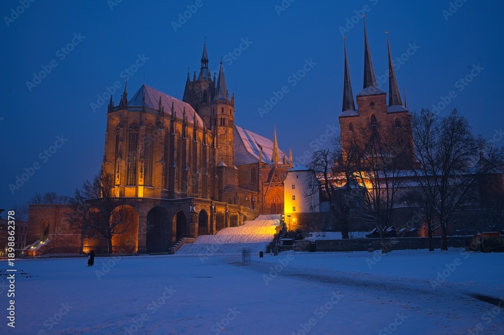Obraz premium cathedral square in Erfurt with view to snow covered cathedral and church Severi at a winter day in the blue hour