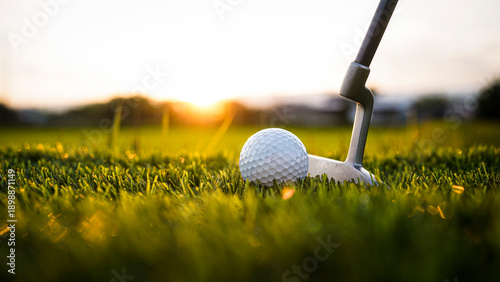 Close-up Shot of Golf Putter Aligning with White Golf Ball in Sunset