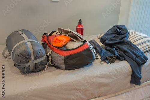 Bedroom of young person, preparing his backpack for camping