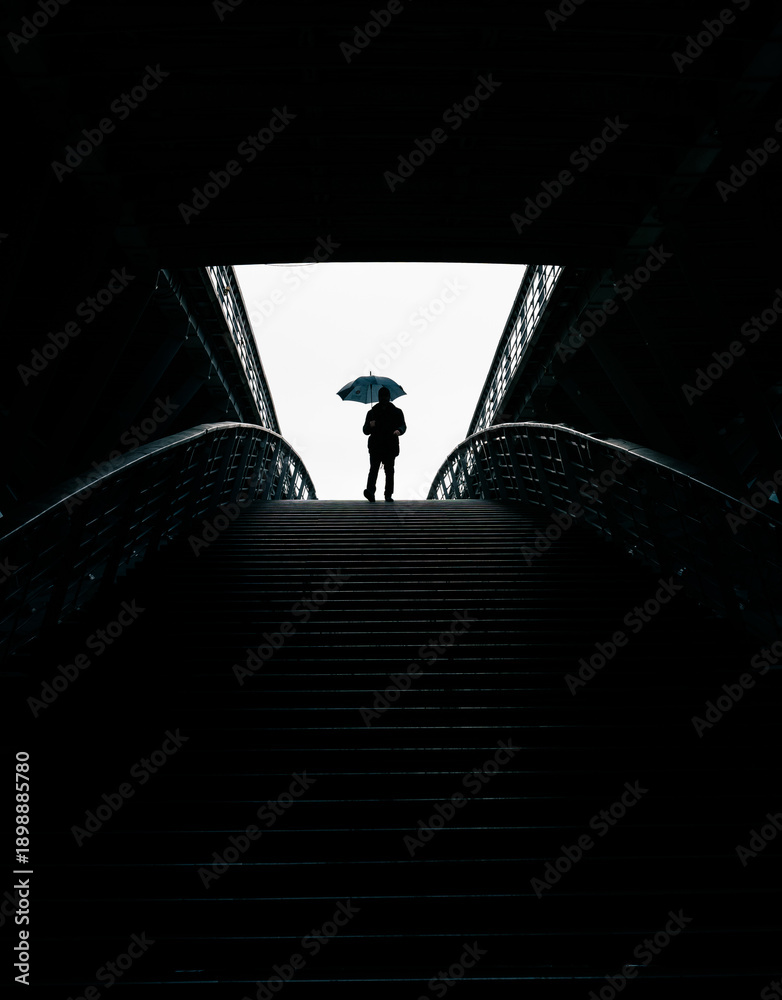Fototapeta premium man with umbrella in a dark tunnel