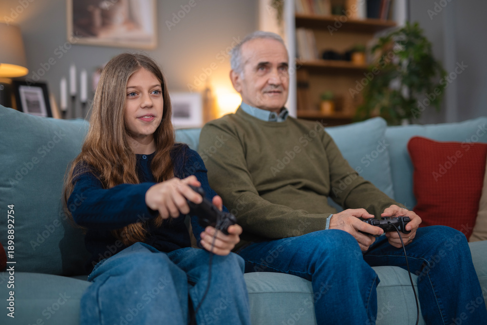 Fototapeta premium Grandpa and granddaughter enjoying video games together