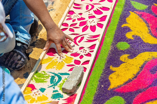 Tableau sur toile Person placing stencil while creating colorful alfombra made of colored sawdust for Holy Week celebrations in Antigua, Guatemala