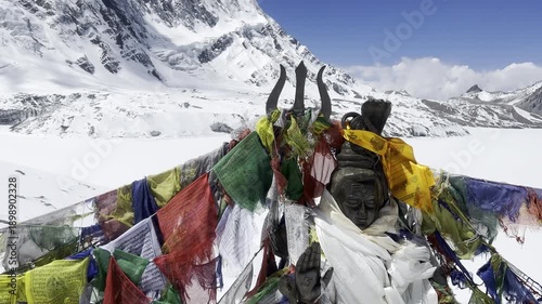 Cinematic 4K scenic shot of a Buddhist prayer wheel and colorful prayer flags with mantras in Nepal. Tibetan spiritual atmosphere, sacred symbols, meditation, Himalayas, divine and peaceful mood.