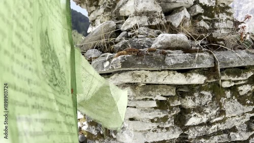Cinematic 4K scenic shot of a Buddhist prayer wheel and colorful prayer flags with mantras in Nepal. Tibetan spiritual atmosphere, sacred symbols, meditation, Himalayas, divine and peaceful mood.