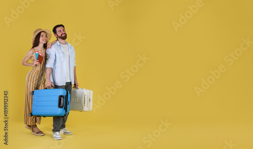 Fotografía Happy couple with suitcases, passports and tickets on yellow background, space f