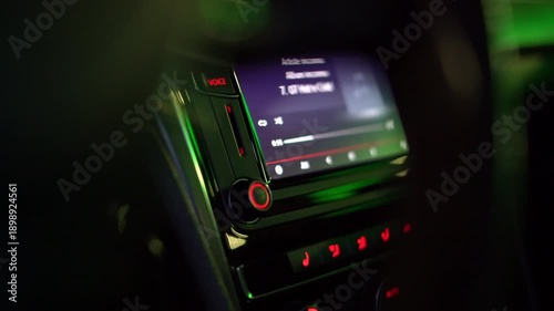 Modern car dashboard multimedia screen playing music at night