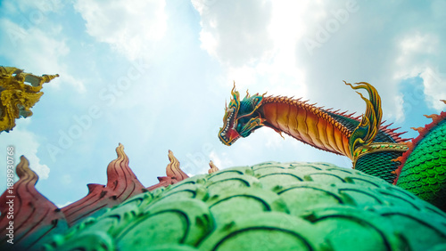 Εκτύπωση καμβά Majestic Naga dragon statue guarding a sacred Thai temple, its ornate scales gleaming under a bright blue sky, evoking deep spirituality and cultural mysticism with vibrant colors