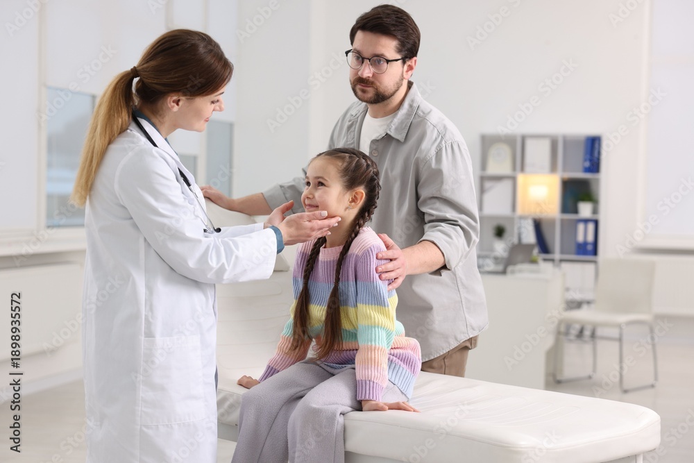 Obraz premium Little girl and her father having appointment with pediatrician in hospital. Doctor examining child