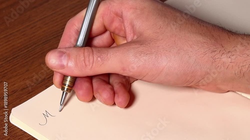 A hand writing entries in a memory book, pasting printed photos. The concept of solo travel, creating unique memories and personal experiences.