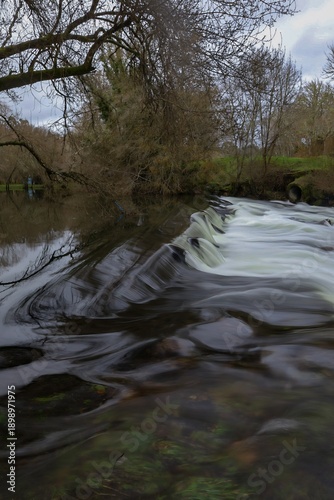 Río con agua en movimiento y larga exposición en paisaje de bosque