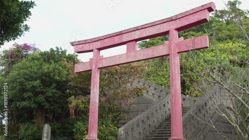 Traditional Red Torii Gate with Stone Stairs in Lush Green Nature