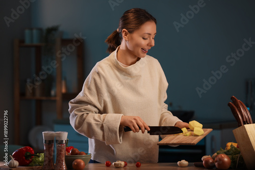 Young woman cutting potato ...