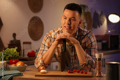Young man cutting vegetable...