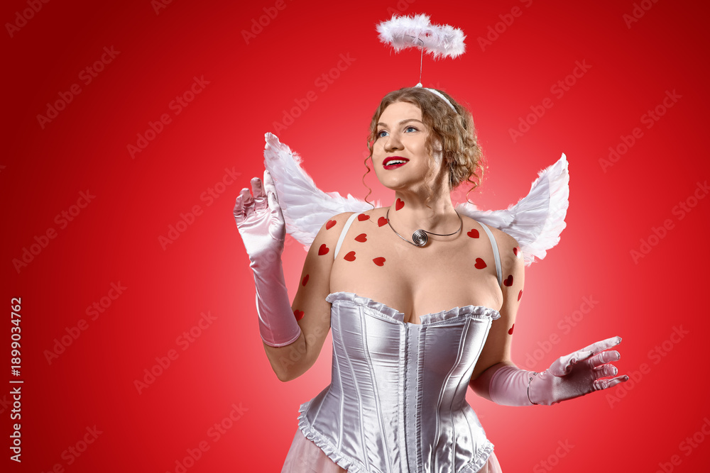 Fototapeta premium Beautiful woman dressed as Cupid on red background. Valentine's Day celebration