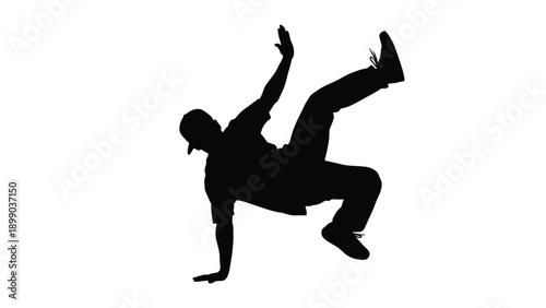 Silhouette of a breakdancer wearing a cap executing a dynamic frozen power move during a street dance performance