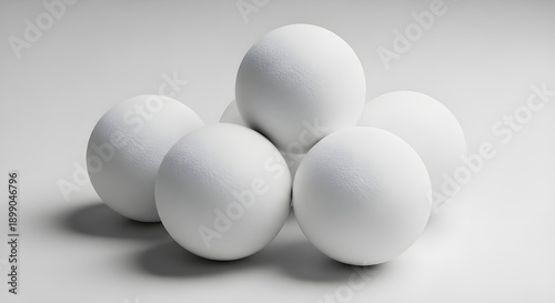 Five neatly arranged white spherical objects on a plain surface