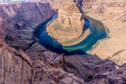 A canyon with a river that is curved and has a blue tint