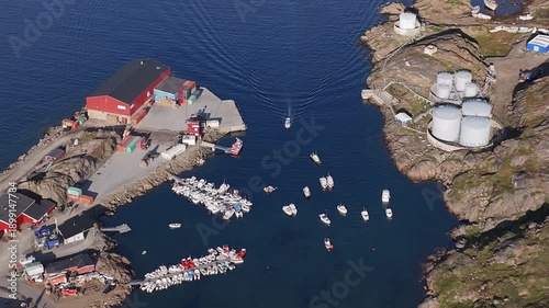 Scenic View of Tasiilaq Harbor and Mountains in East Greenland. Wide shot of Tasiilaq town and harbor in East Greenland. The footage captures the colorful wooden houses, small boats in the marin