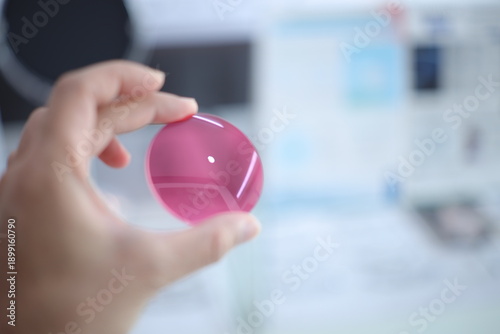 Hand a doctor holding pink sunglasses leans, pink lense glasses in hand 