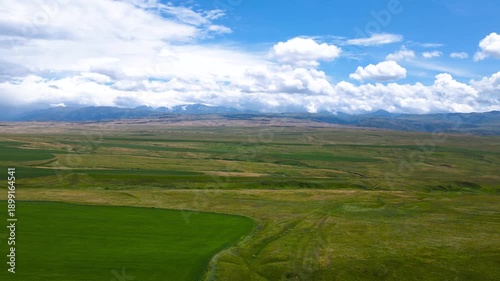 green fields at the foot of the mountains. a mountain plateau