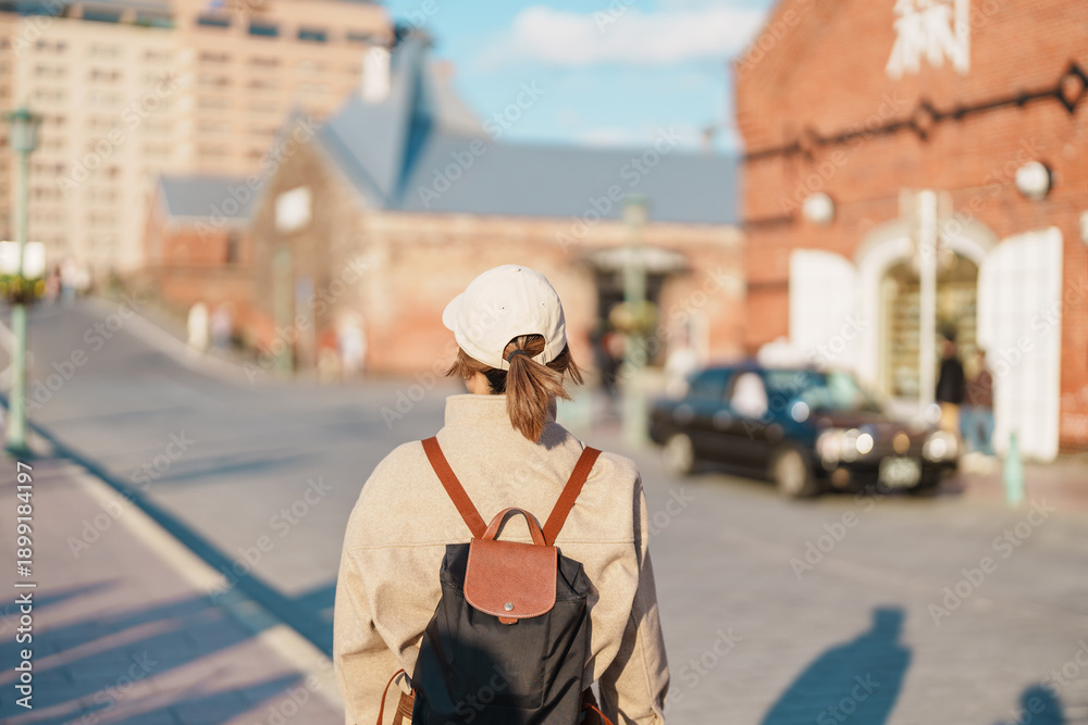 Obraz premium Woman tourist Visiting in Hakodate, happy Traveler sightseeing Kanemori Red Brick Warehouse in spring season. landmark and popular for attractions in Hokkaido, Japan. Travel and Vacation concept