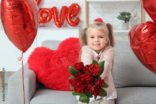 Cute little girl with red roses sitting in room decorated for Valentines Day